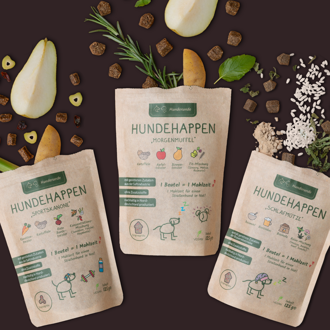 Drei Beutel Hunderunde Hundehappen Probierpaket, umgeben von Birne, Kräutern, Reis und Würfeln - für einen gesunden Start dank natürlicher Vitamine.