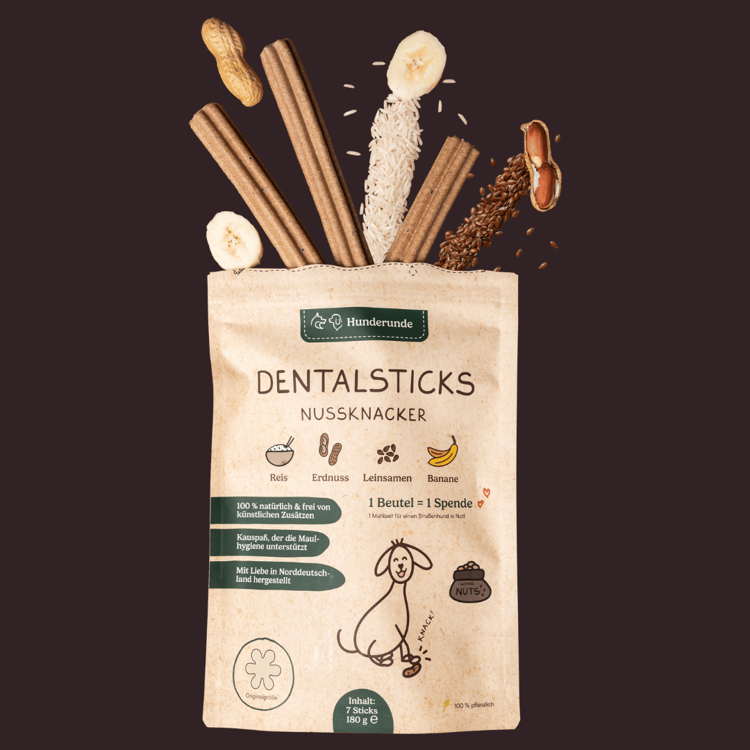 Oben sehen Sie eine Tüte Hunderunde Dental Sticks Nussknacker mit Zutaten wie Banane, Reis und Erdnüssen.