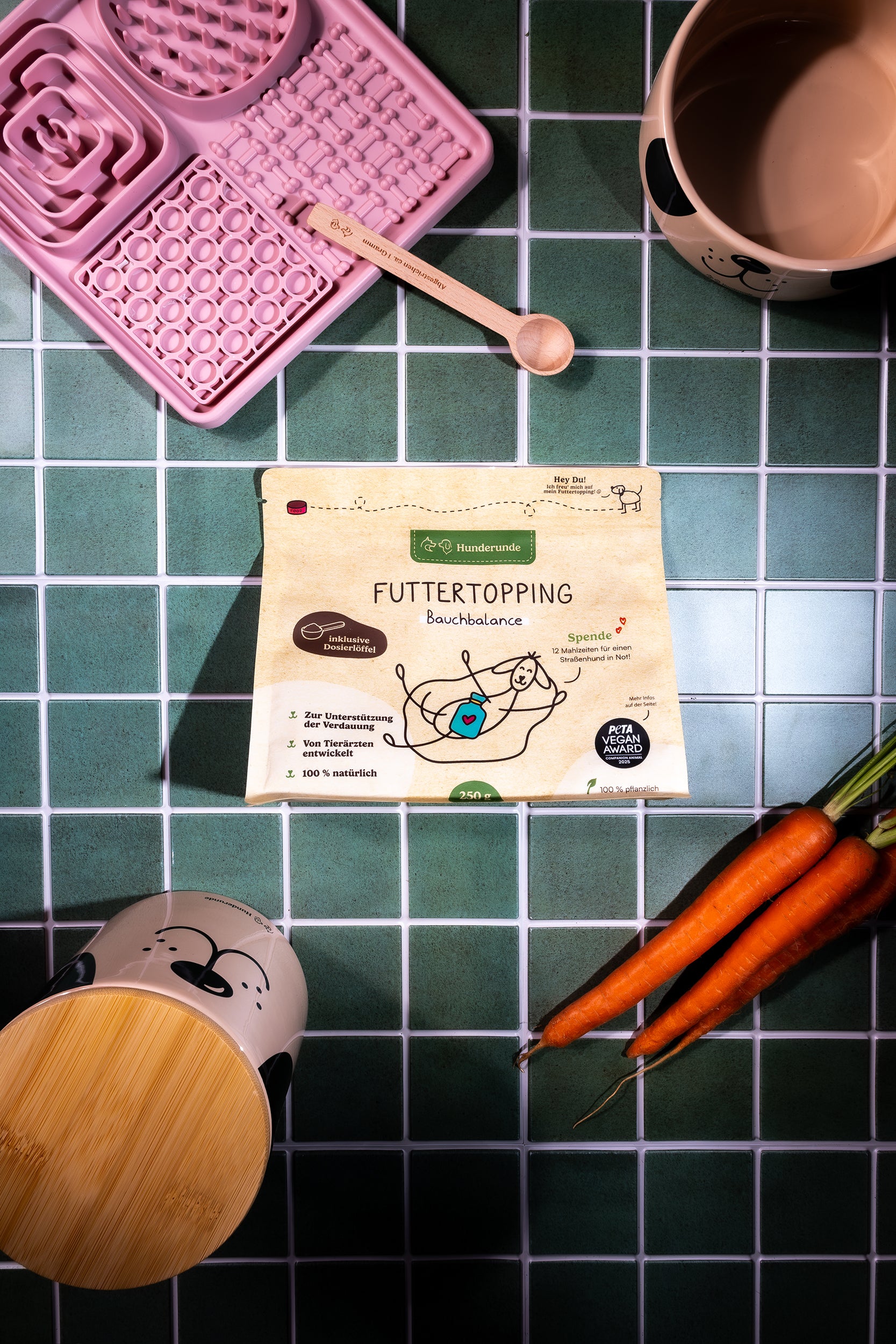 Bauchbalance Topping Produkt mit Dosierlöffel, Napf und Karotten